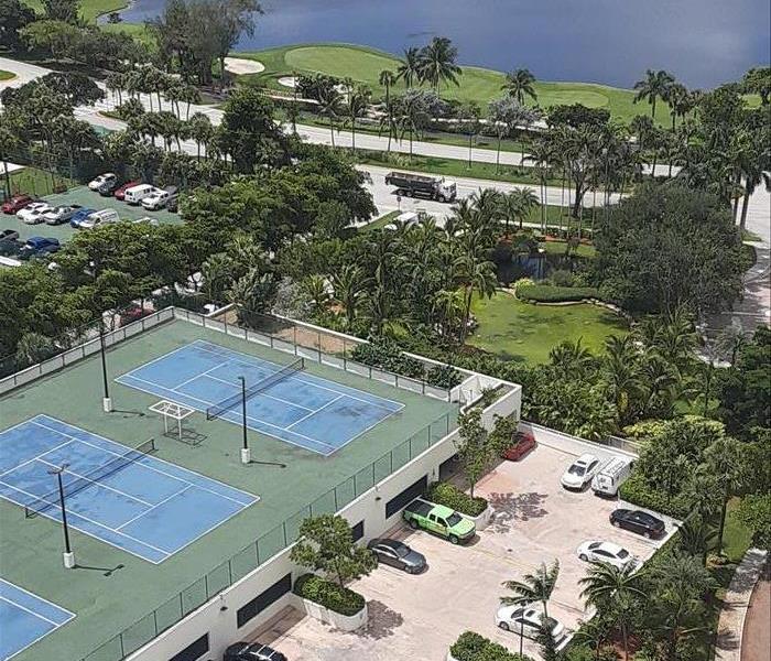 Overhead view of a courtyard with tennis courts. 