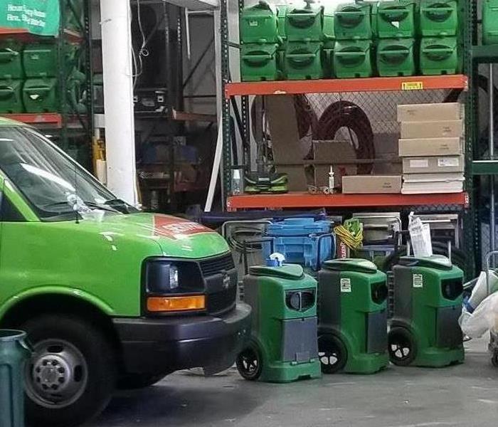 Green SERVPRO trucks lined up outside. 