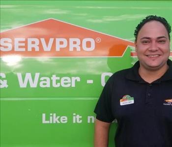 Servpro rep standing in front of a company vehicle